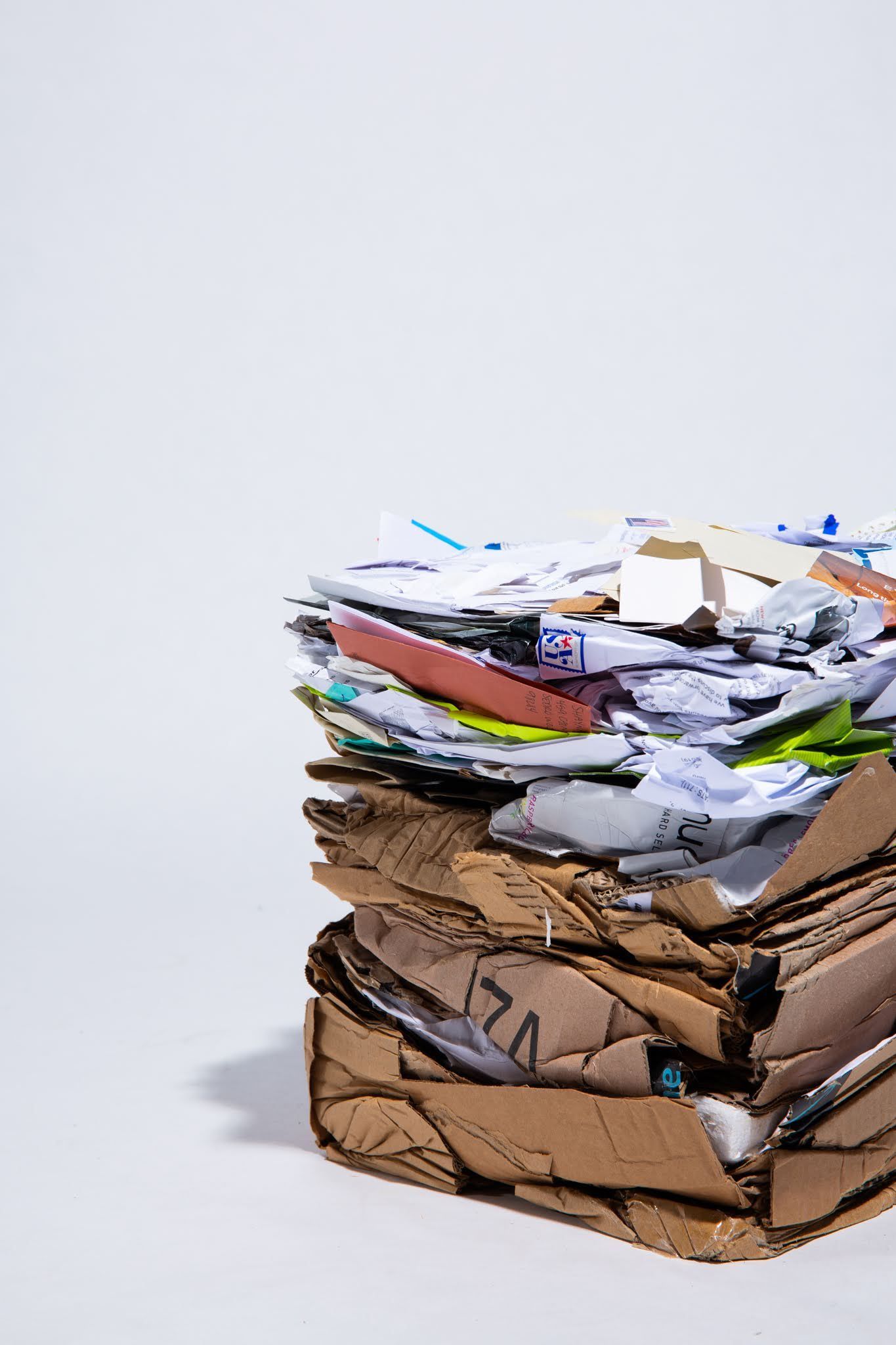 Pile of crushed cardboard and paper against a white background; art by Matt Remsbecher. 