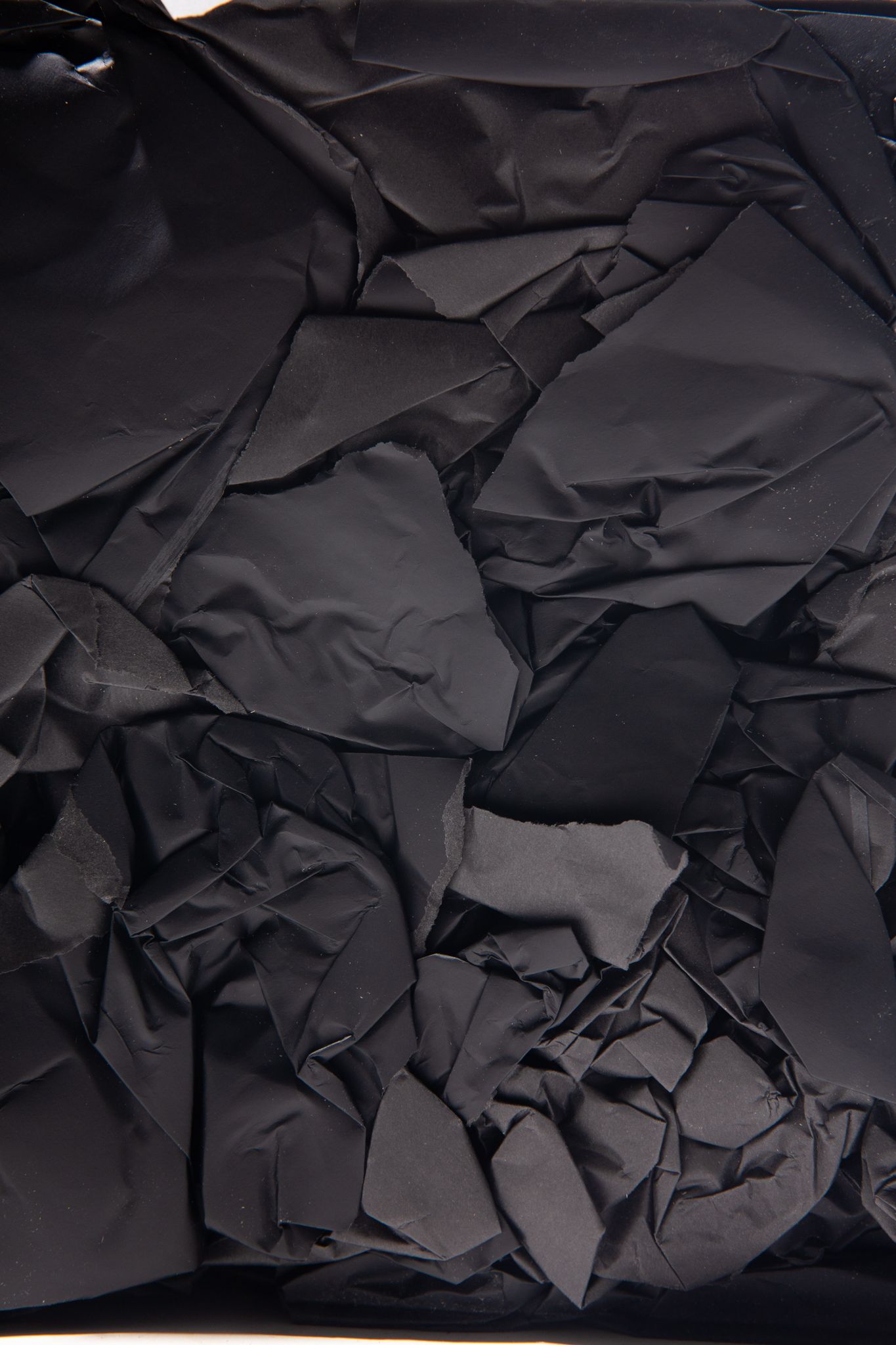 Crushed black fabric, heavily textured and layered, filling the frame; art by Matt Remsbecher. 