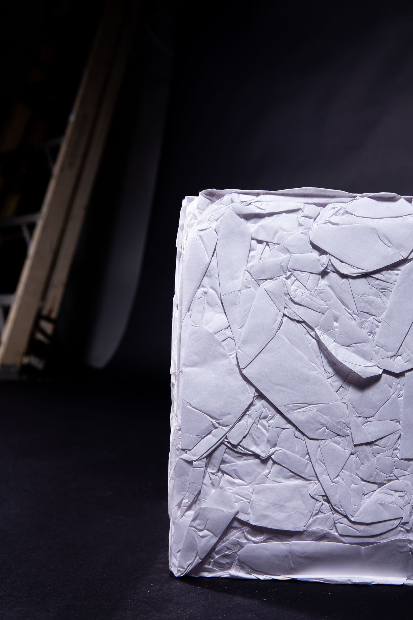 Close-up of a textured, light gray square block; art by Matt Remsbecher. Wooden ladder frame partially visible on left.