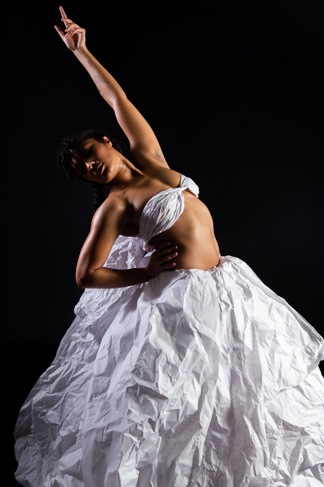 Ballerina in white dress arches backward, arm raised. Black background; art by Matt Remsbecher. 