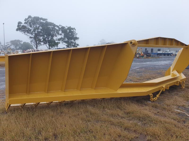 A large yellow object is sitting in the middle of a field