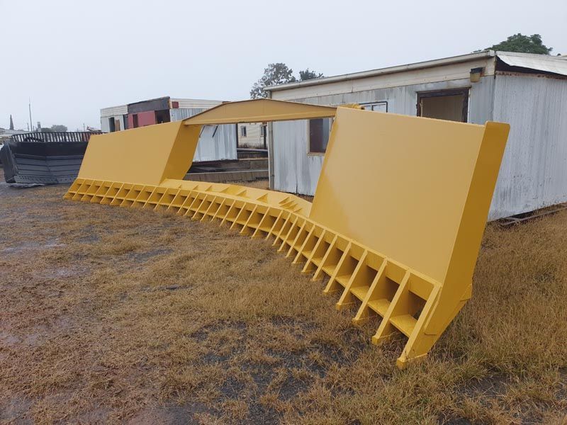 A large yellow object is sitting in the middle of a field