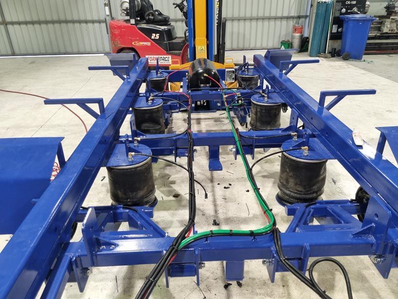 A blue machine with a forklift in the background