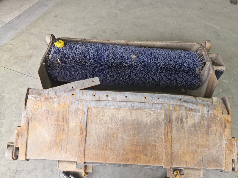 A blue brush is sitting inside of a wooden box