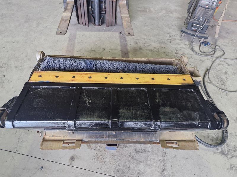 A black and yellow item is sitting on a wooden pallet