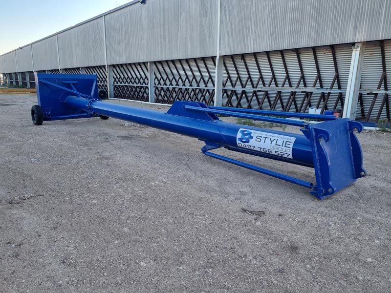 A blue pipe is sitting on the ground in front of a building.