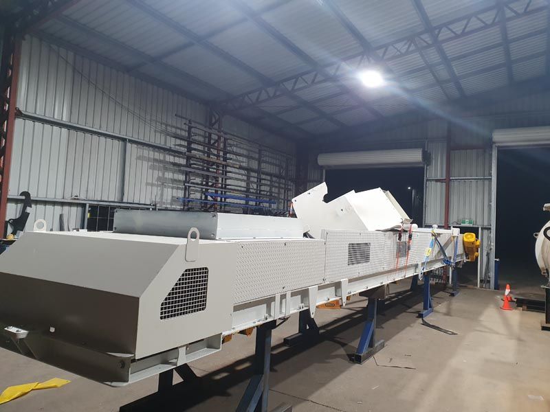 A large white machine is sitting inside of a building.