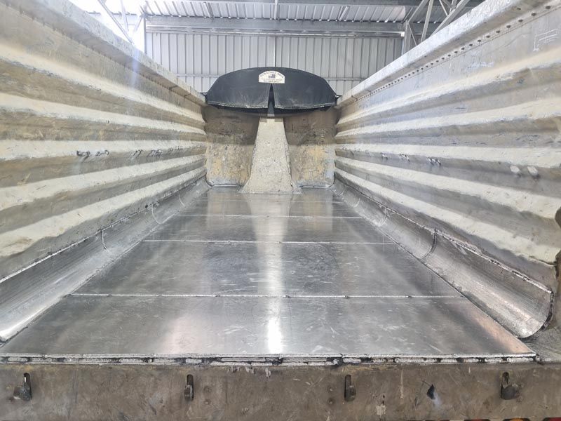The inside of a dump truck with a metal floor.