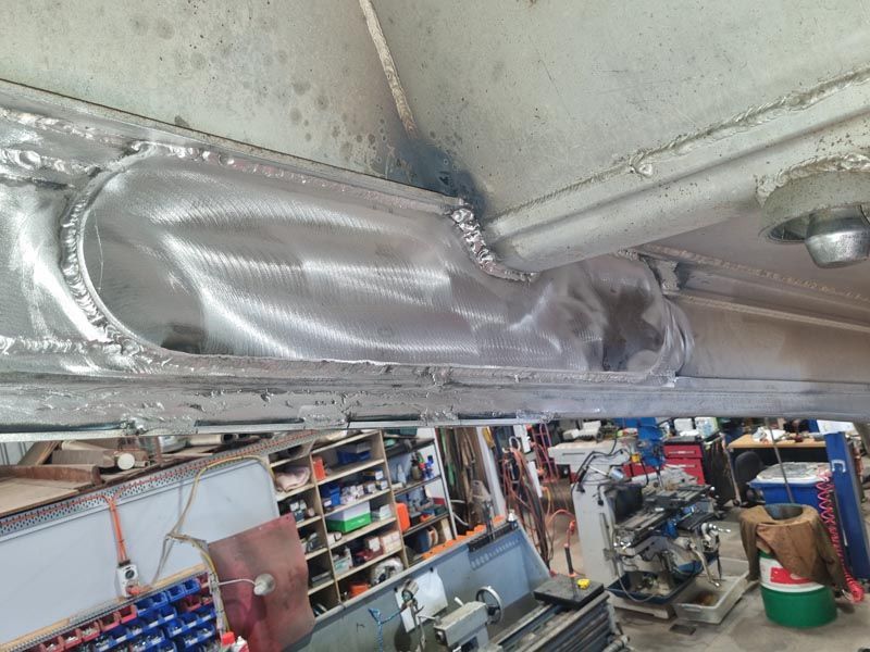 A metal pipe is hanging from the ceiling of a garage.