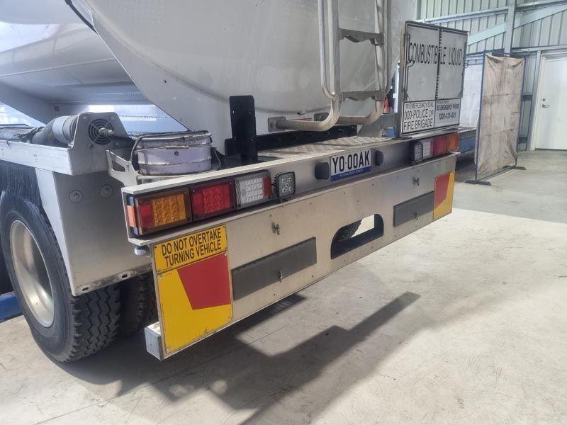 The back of a truck with a license plate that says ' volvo ' on it is parked in a garage.
