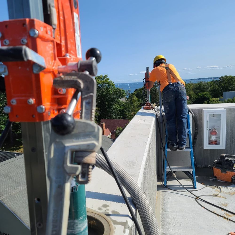 A man is standing on a ladder next to a machine