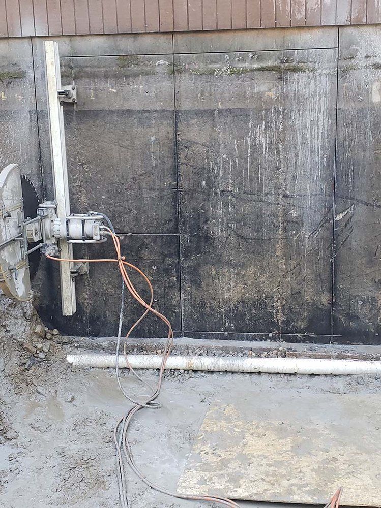 A machine is cutting a hole in a concrete wall.