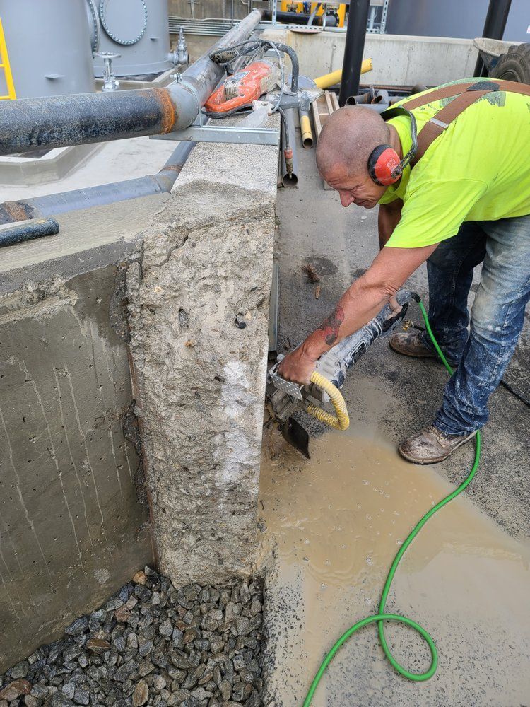 A man is cutting concrete with a circular saw.