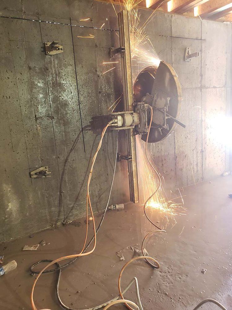 A person is cutting a hole in a wall with a machine.