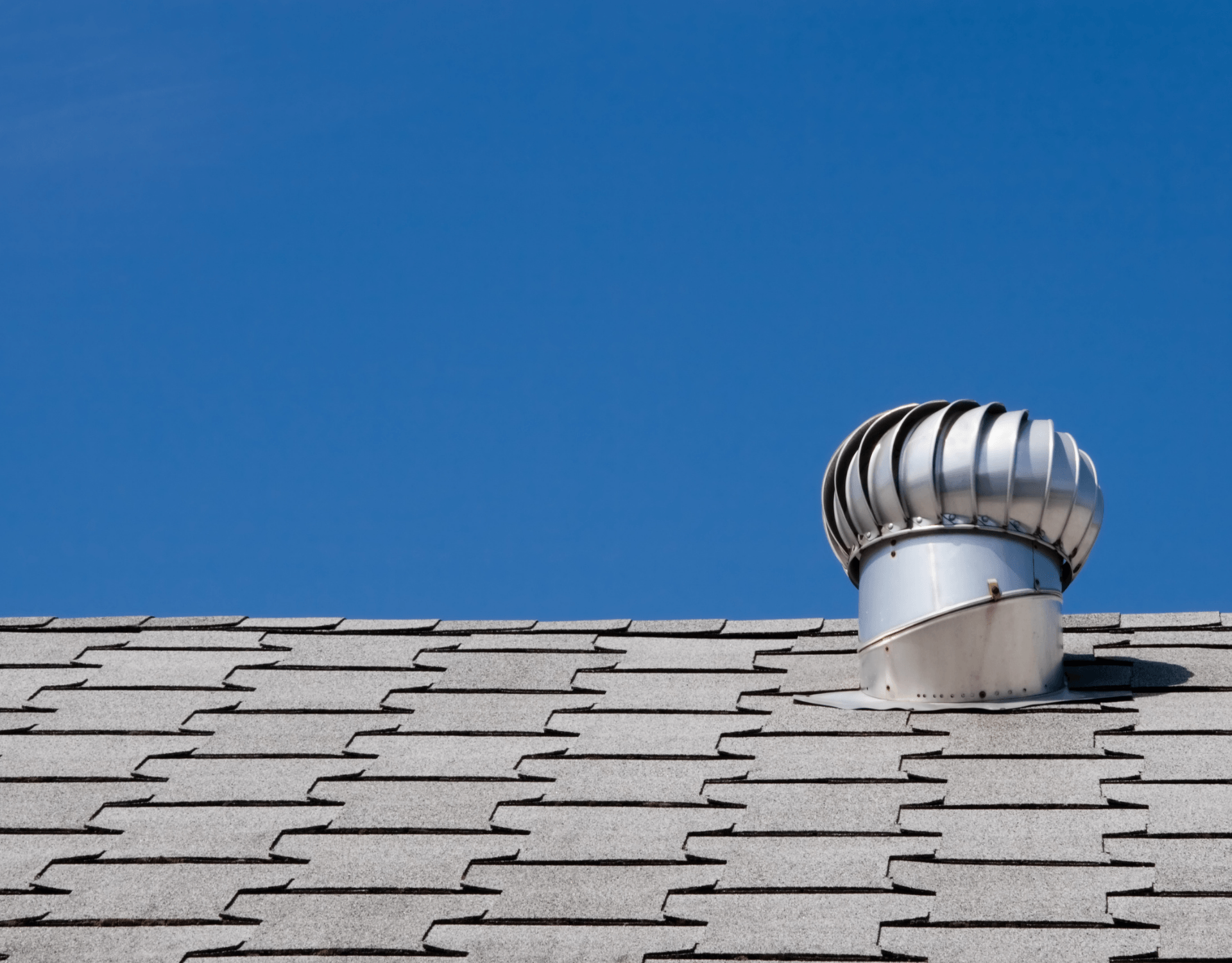 Rooftop turbine vent against a clear blue sky