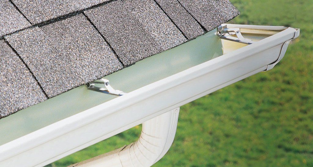 White gutter on shingled roof with a detached end cap