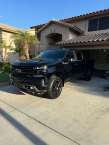 A black truck is parked in front of a house.