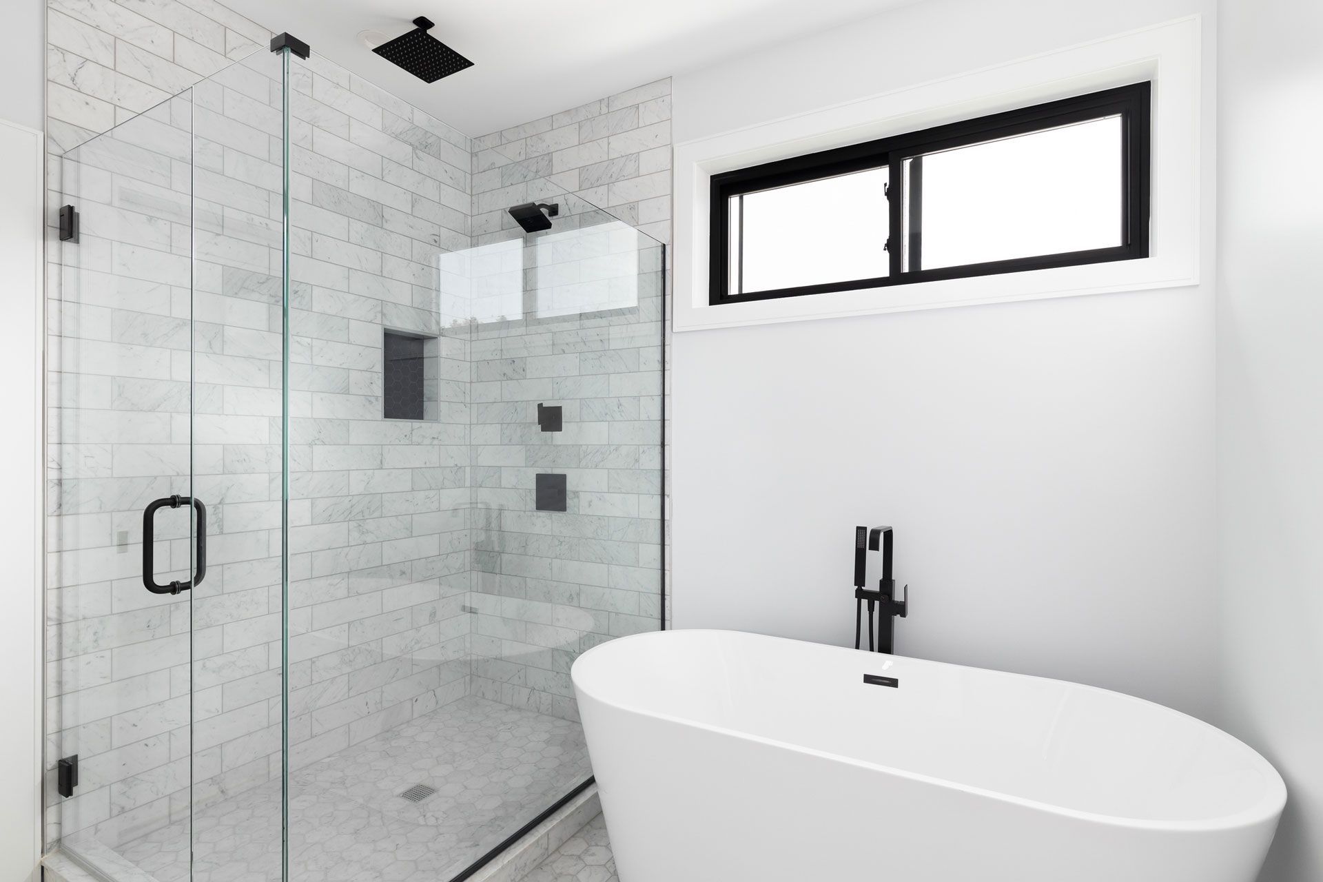 A bathroom with a tub, shower, and window.