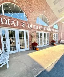 Exterior of Dial & Dudley Funeral Home with arched windows and doors. Pumpkins and fall decor.