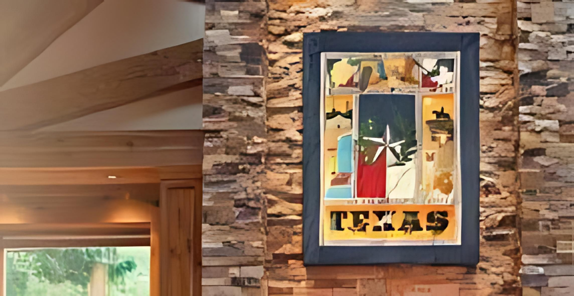 A picture of texas is hanging on a stone wall