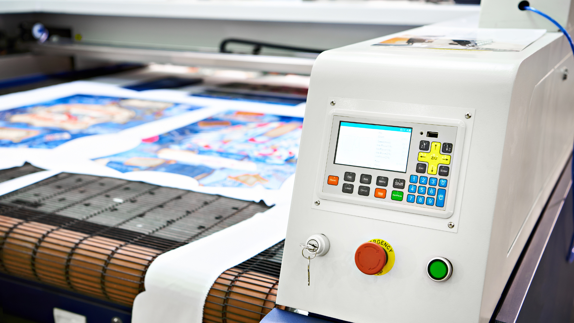 A large printer is printing a lot of papers on a conveyor belt.