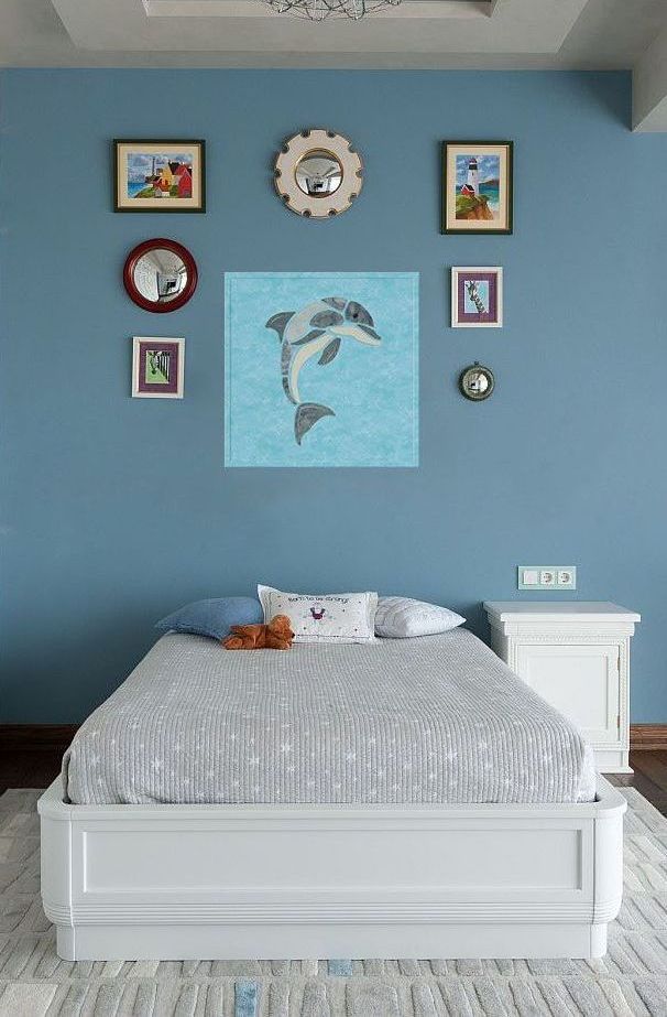 There is a picture of a dolphin on the wall above the bed.