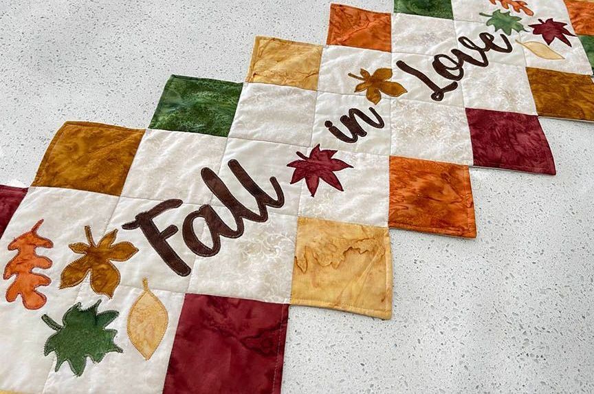 A table runner with the words `` fall in love '' embroidered on it.