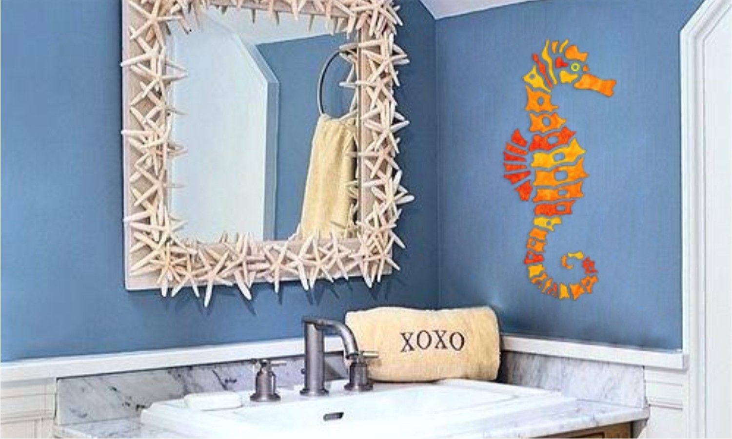 A bathroom with a sink , mirror , and seahorse on the wall.