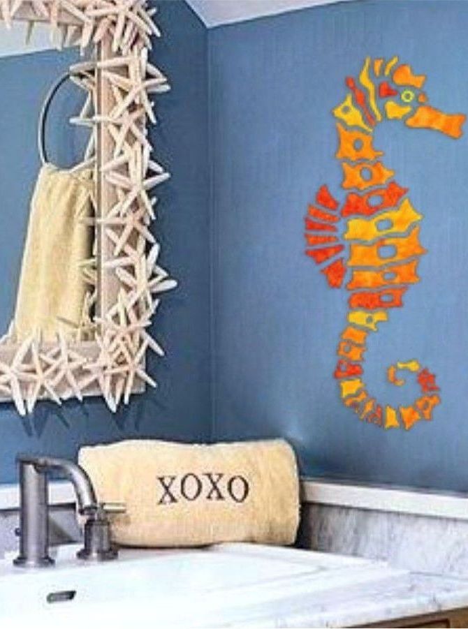 A bathroom with a seahorse on the wall and a towel that says xoxo