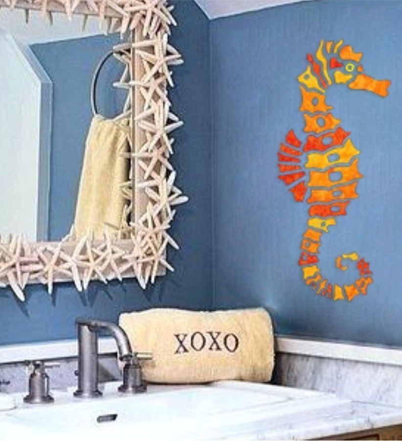 A bathroom with a seahorse on the wall and a towel that says xoxo