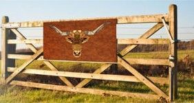 A wooden gate with a picture of a bull on it.