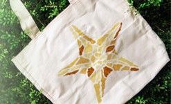 A white tote bag with a starfish painted on it.