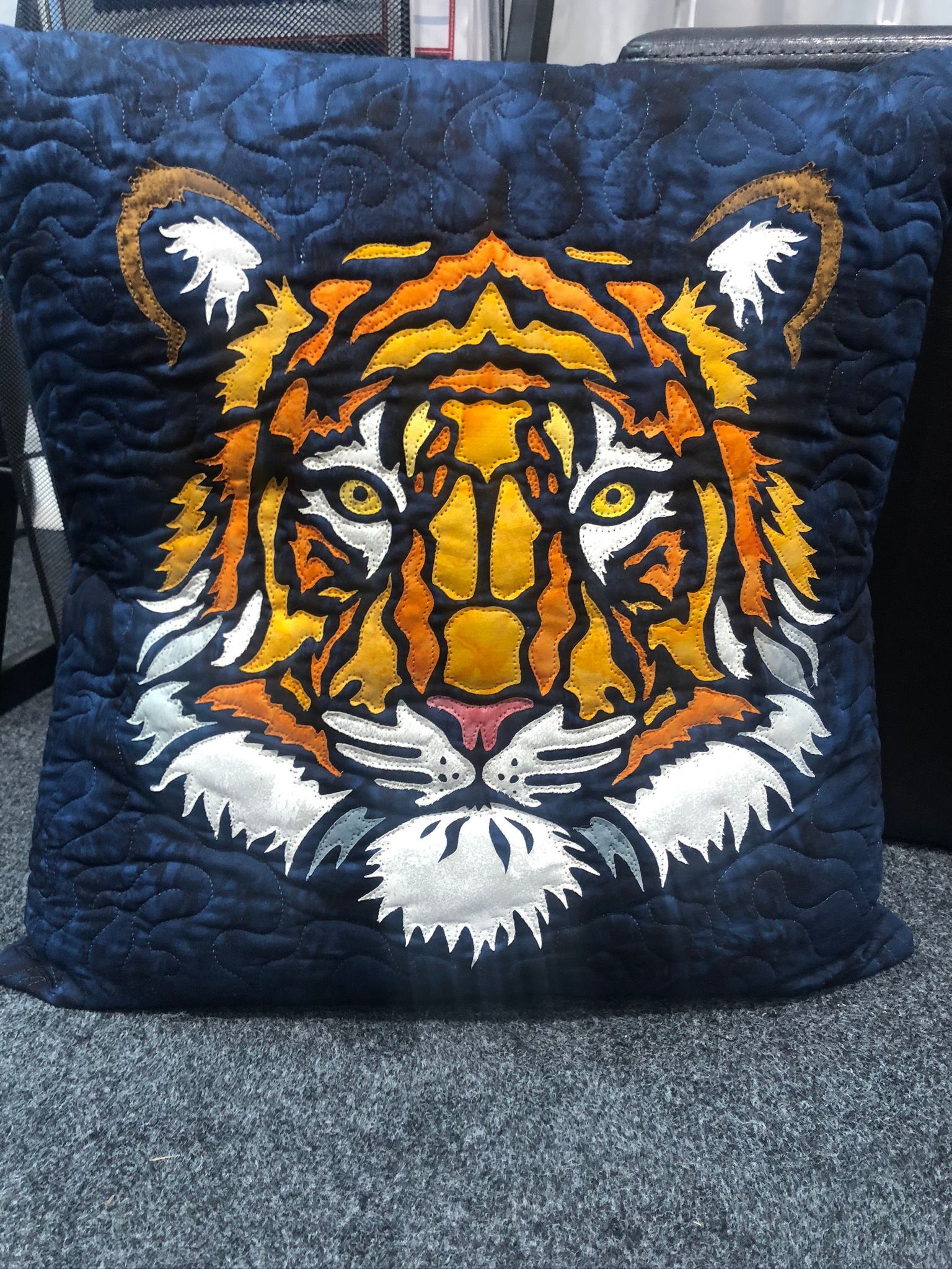 A blue pillow with a tiger face on it