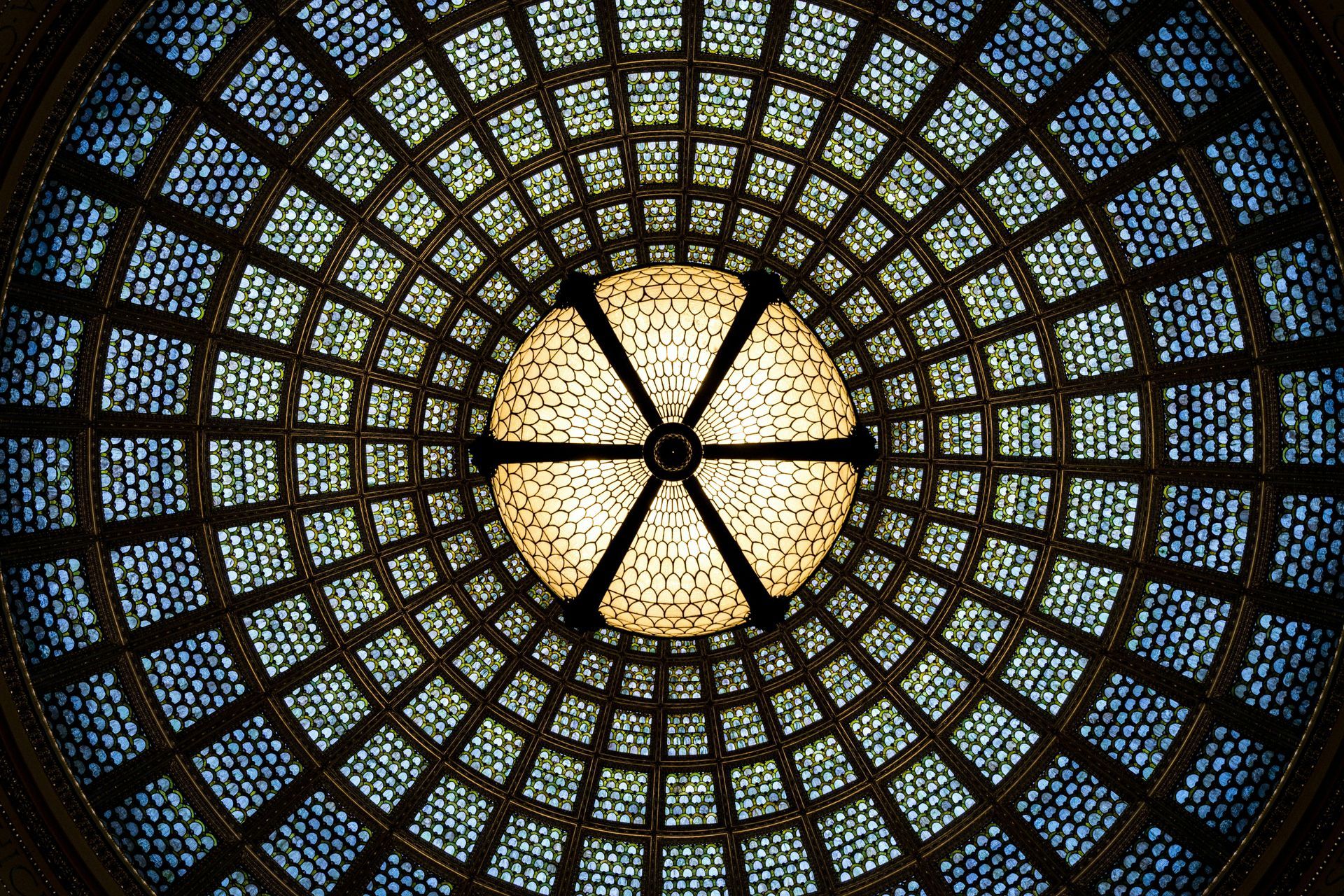 Looking up at the ceiling of a building with stained glass windows