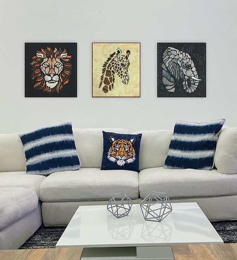 A living room with a couch , coffee table , and three paintings of animals on the wall.