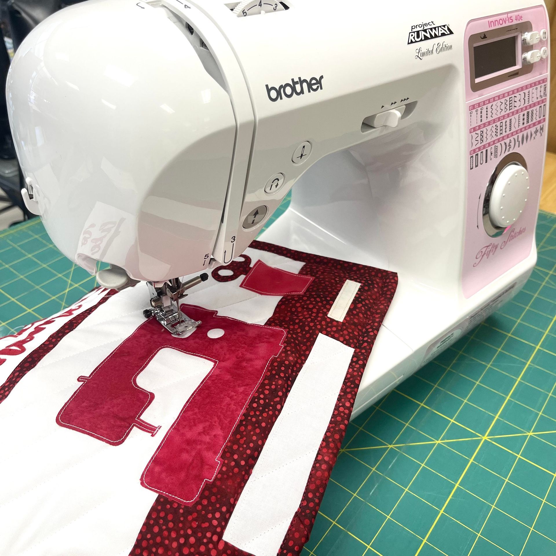 A white brother sewing machine is sitting on a green cutting mat