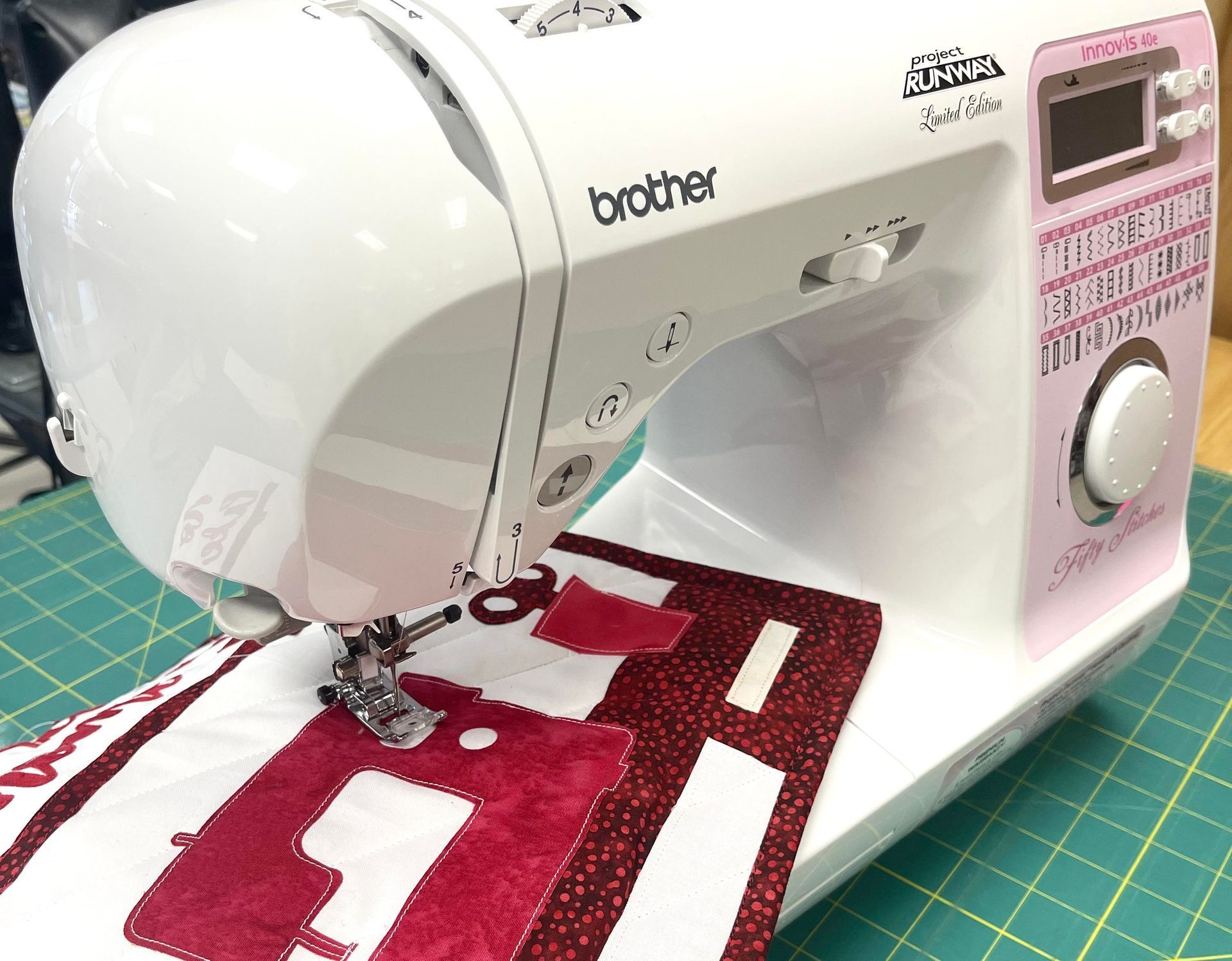 A brother sewing machine is sitting on a cutting mat