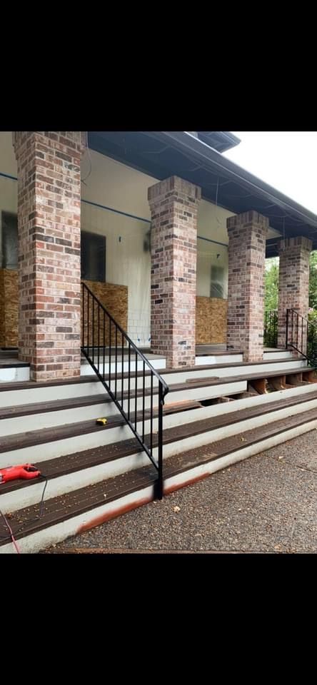 A house with a porch and stairs with a metal railing.