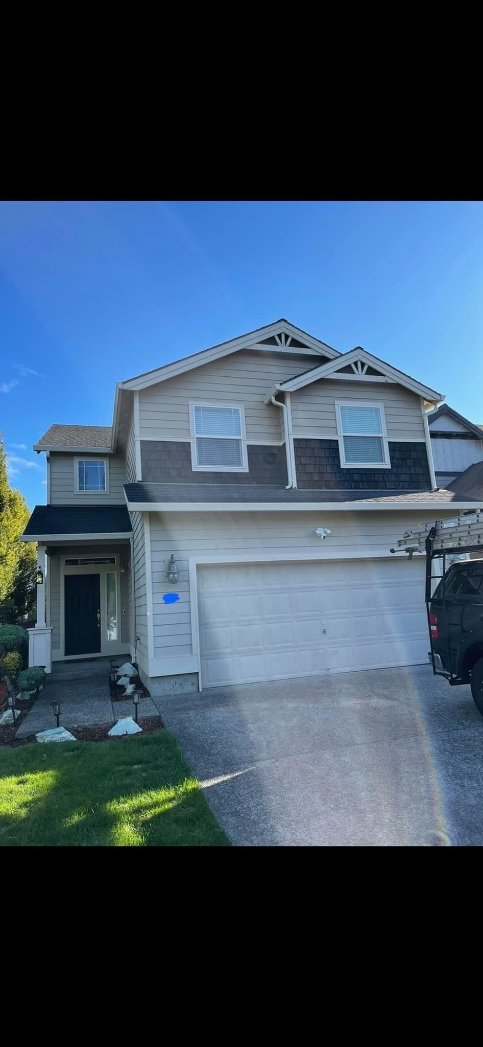 A large house with a white garage door and a truck parked in front of it.