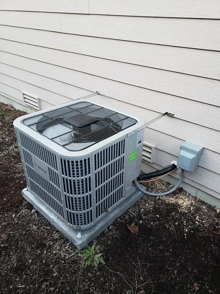 Air conditioning unit outside a light-colored house.