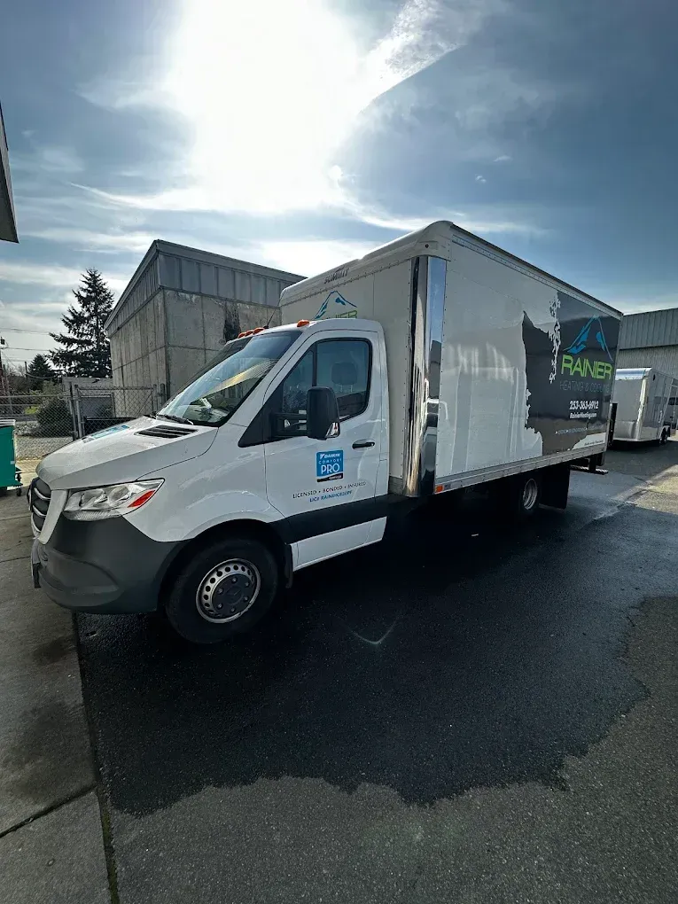 White box truck parked outdoors with logo on the side.