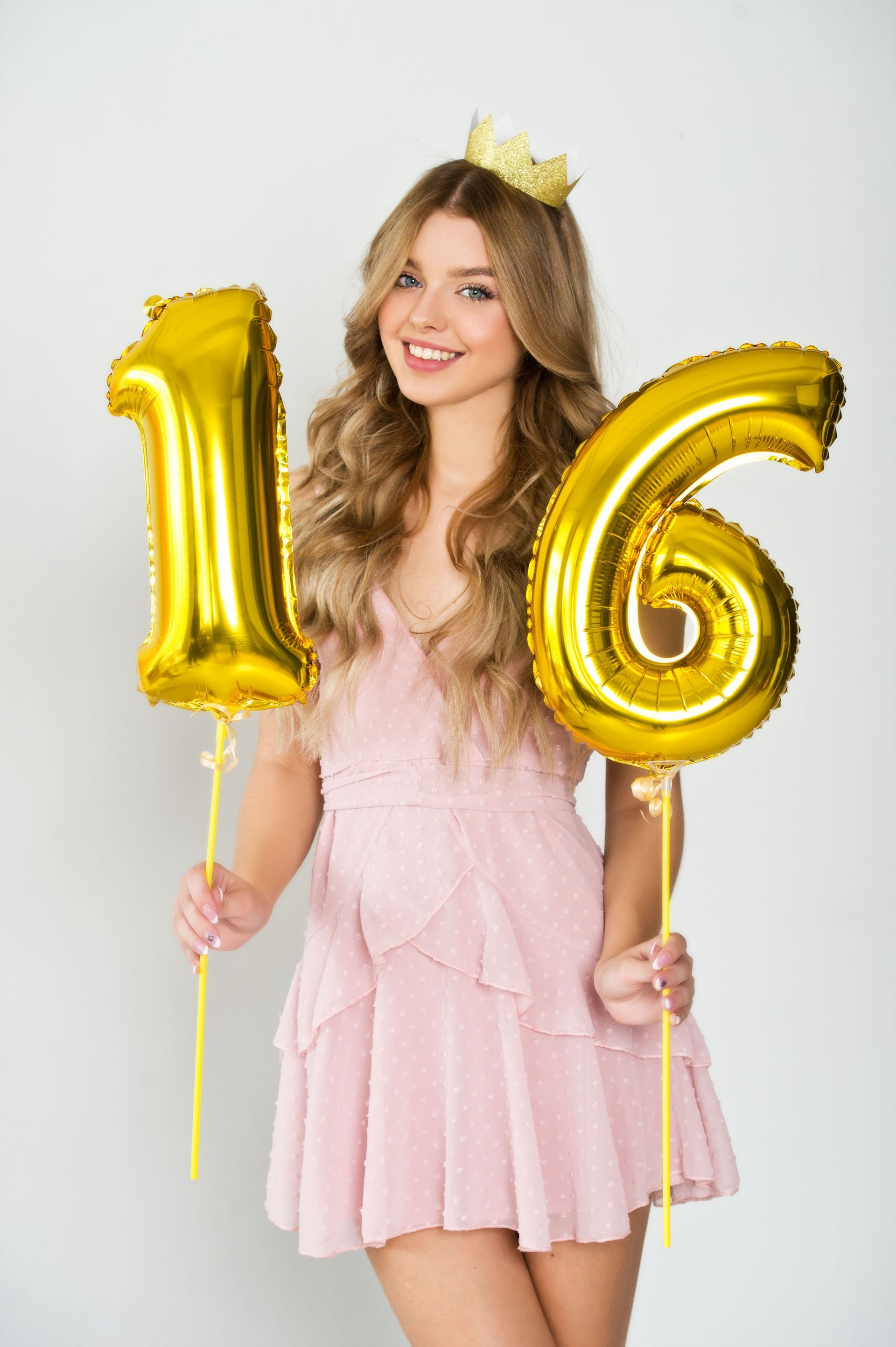 young lady with crown and holding 16 numbers