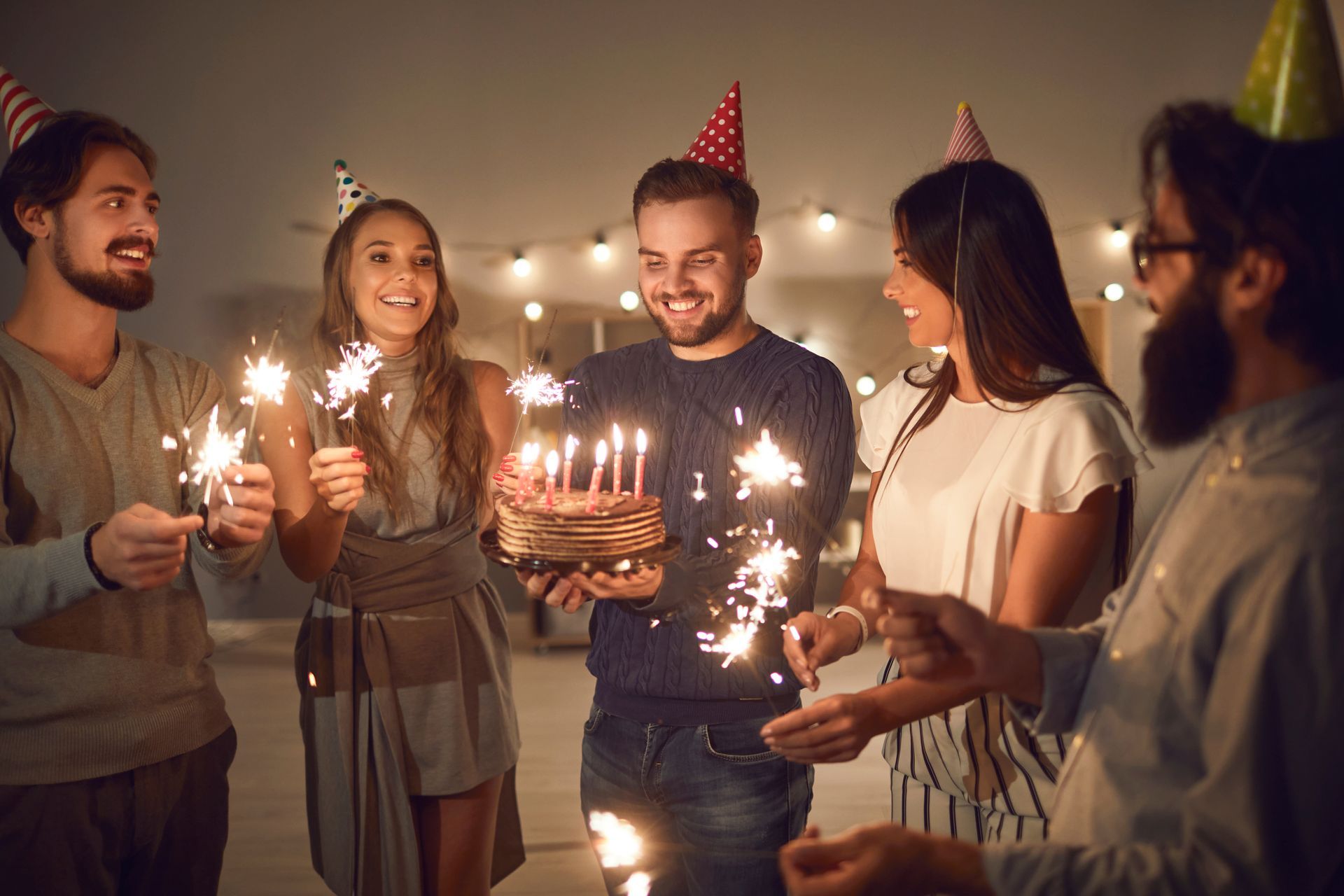 man holding birthday cake with friends