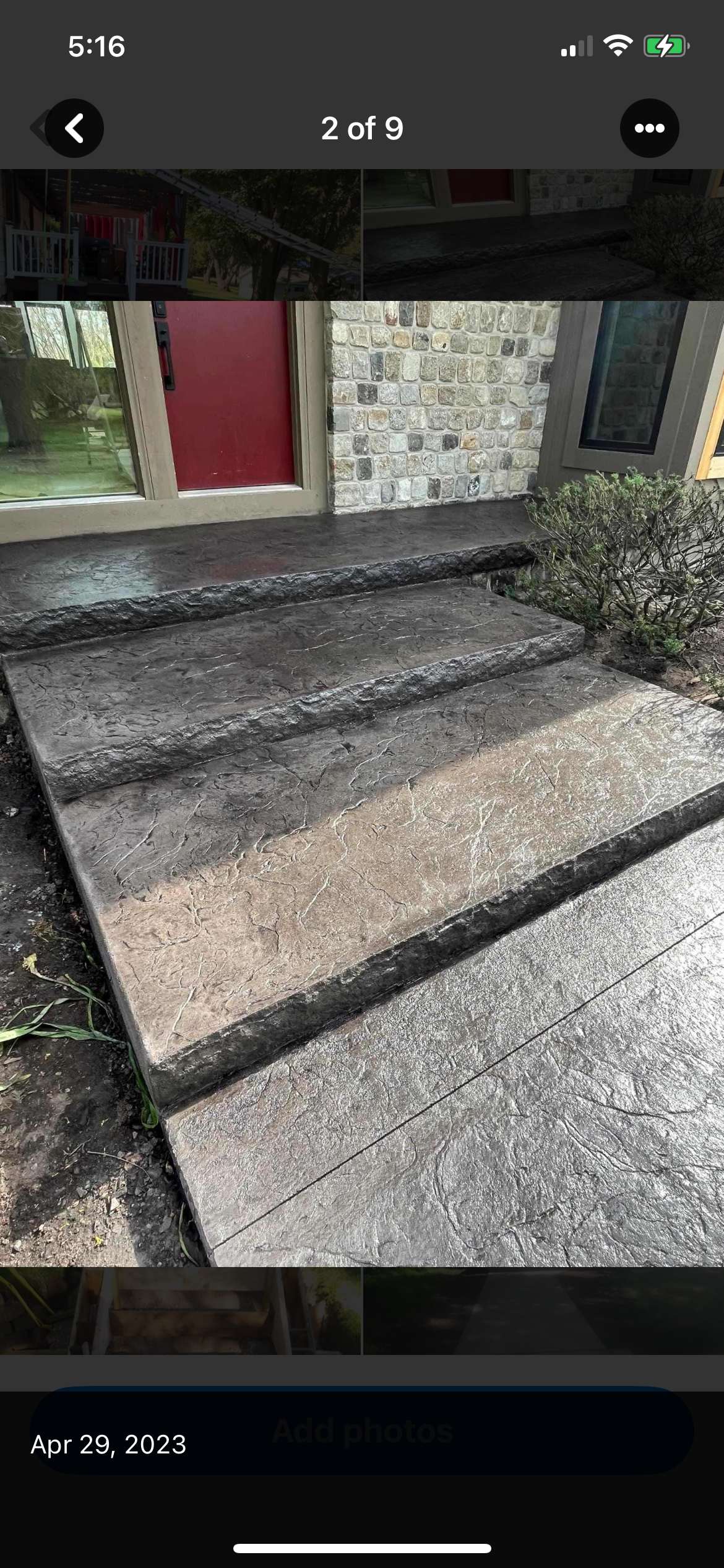 Concrete steps leading up to a building with a red door. The steps are weathered and textured.