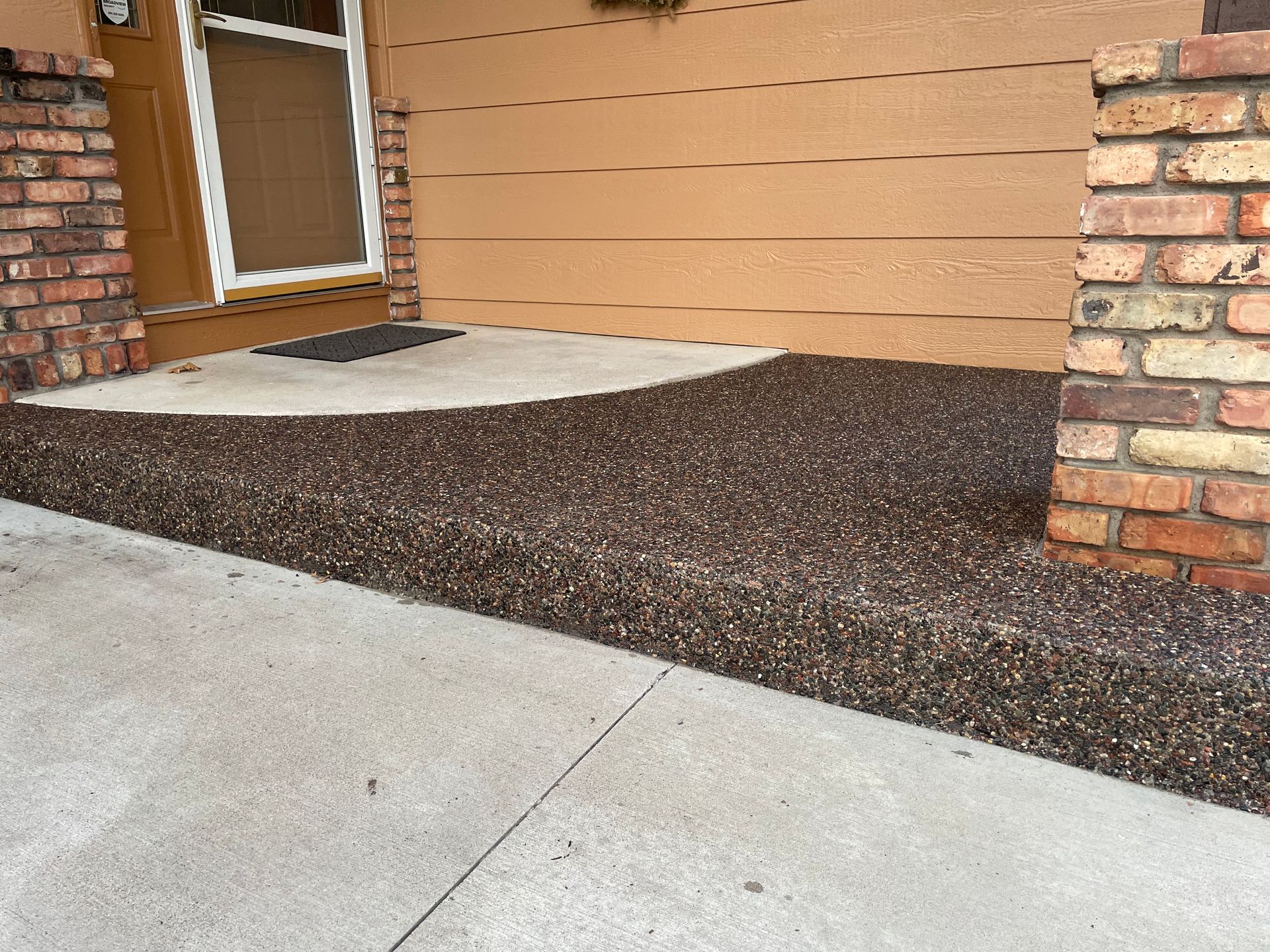 A brick building with a concrete walkway in front of it