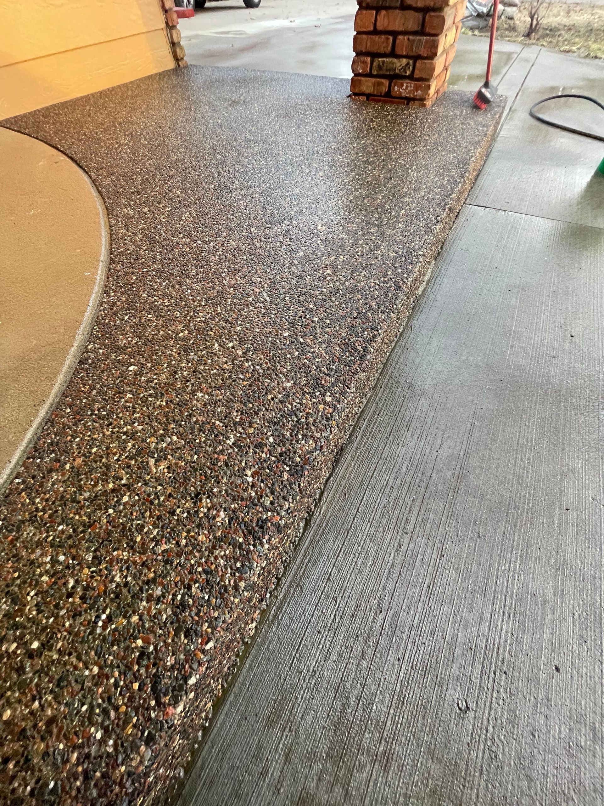 A close up of a concrete floor with a brick wall in the background.
