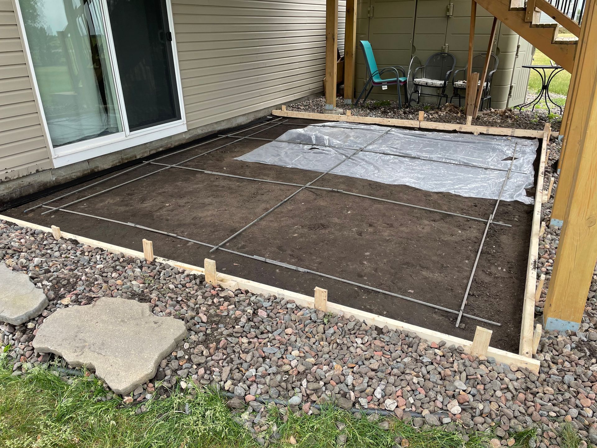 A patio is being built in the backyard of a house.