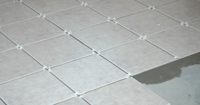 A close up of a tiled floor with a few tiles missing.