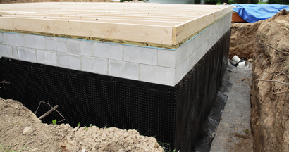 A foundation for a house is being built in a hole in the ground.