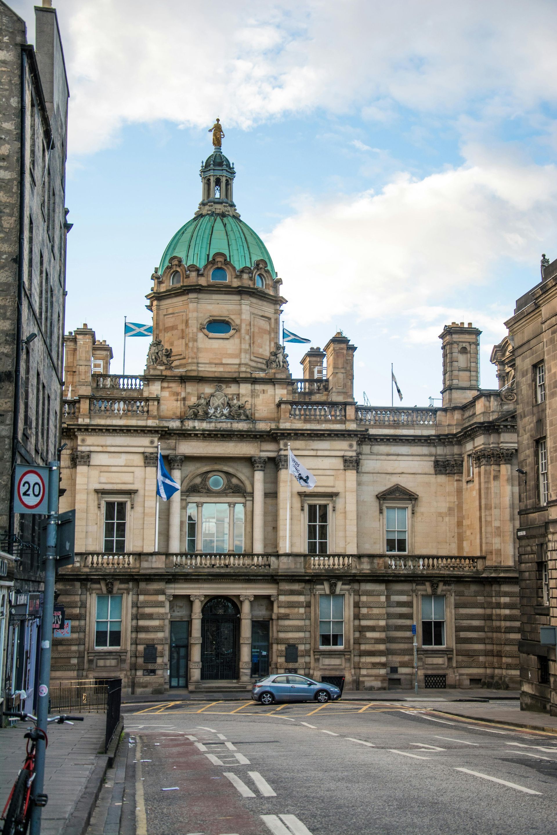 A group of people sits around a long table in a bright, modern office conference room, working on laptops.